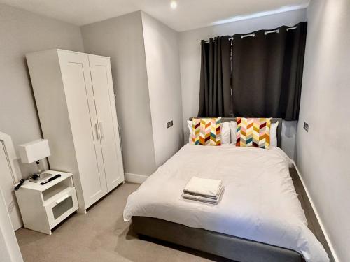 a small bedroom with a bed with a black window at Upminster Bridge Station Excel House in Hornchurch