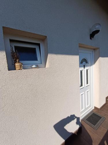a building with a window and a door with a plant at Hotel Guesthouse Stari Jasen in Zagreb