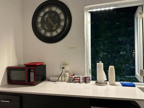 a kitchen counter with a microwave and a clock on the wall at La Perla Suite in San Juan