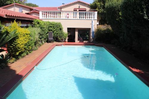 una grande piscina blu davanti a una casa di Villa Stella Guest House a Edenvale