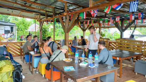 un groupe de personnes assises à des tables dans un restaurant dans l'établissement Angin Mamiri Rinjani Cottages And Restaurant, à Senaru