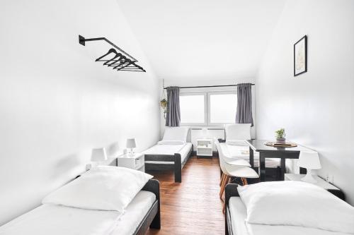 a living room with white furniture and a table at Hostel L44 in Nowy Targ