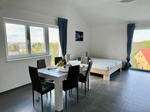 uma sala de jantar com uma mesa e cadeiras e uma cama em Byt apartman 2rooms 76m2 all new em Praga