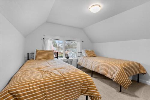 two beds in a room with white walls at The Birch House in Coeur d'Alene