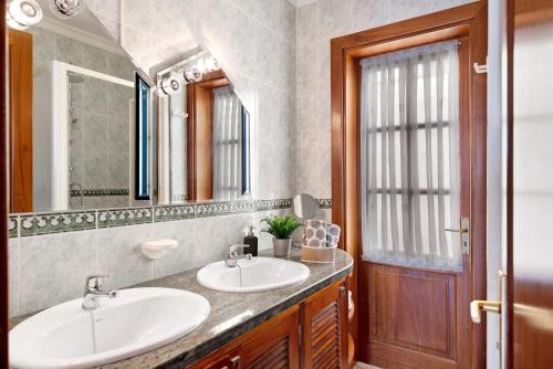a bathroom with two sinks and a mirror at Casa Vista Hermosa in Playa Blanca