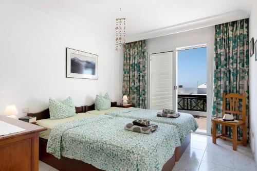a bedroom with two beds and a balcony at Casa Vista Hermosa in Playa Blanca