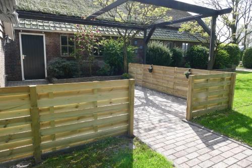 a wooden fence in front of a house at Vakantiewoning 't Stookhok Gasselte in Gasselte