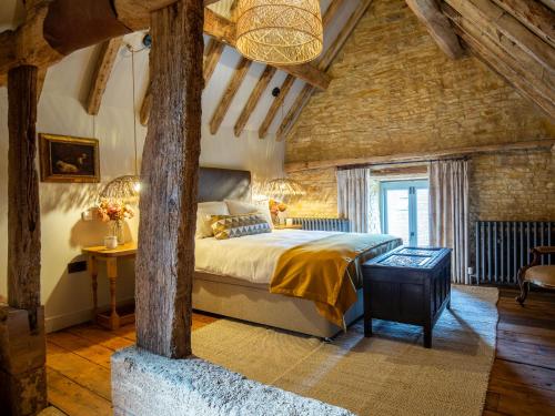 a bedroom with a large bed in a brick wall at The Stables at Stoneythorpe in Southam