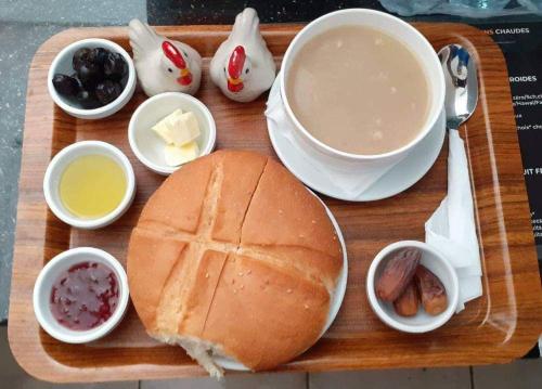 a wooden tray with a sandwich and a cup of coffee at Tommy Tour Sahara in Dakhla