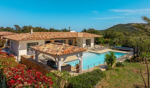 une image d'une maison avec piscine dans l'établissement Villa Les Arbousiers - Piscine Chauffée Sécurisée - 210m2 - 4 Suites, à Porto-Vecchio