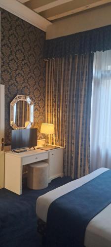 a bedroom with a bed and a desk and a mirror at Duodo Palace in Venice