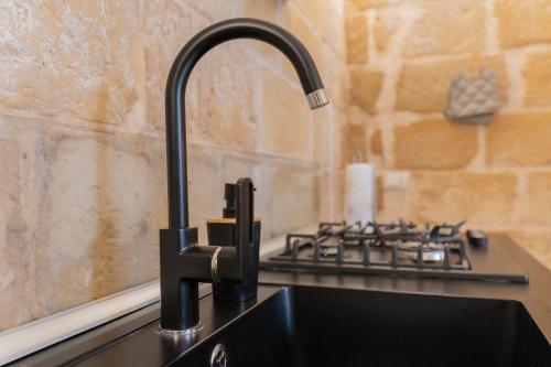 a kitchen sink with a faucet next to a stove at DIMORA BAROCCA Apartment Irene in Lecce
