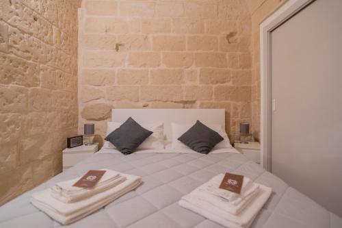 Un dormitorio con una cama blanca con toallas. en DIMORA BAROCCA Apartment Irene en Lecce