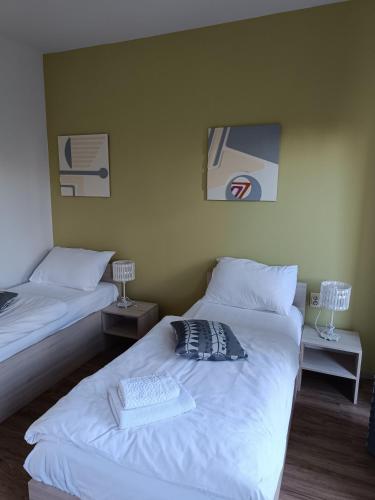 a bedroom with two beds and two tables with lamps at Hotel Guesthouse Stari Jasen in Zagreb