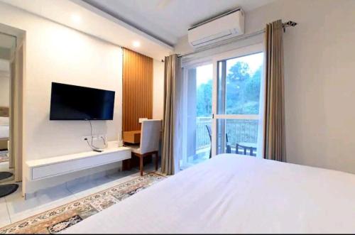 Schlafzimmer mit einem Bett, einem TV und einem Fenster in der Unterkunft Angel homes in Ghaziabad