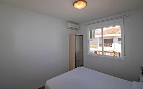 a bedroom with a bed and a window at Tres Playas Primera línea de mar - ALBERT VILLAS Alcossebre in Alcossebre