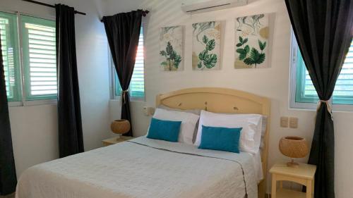 a bedroom with a bed with blue and white pillows at Excelente apartamento en Las Terrenas, Playa Punta Popi. in Las Terrenas