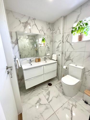 a white bathroom with a toilet and a sink at Fantástico T3 Porto - 6 Pessoas in Porto