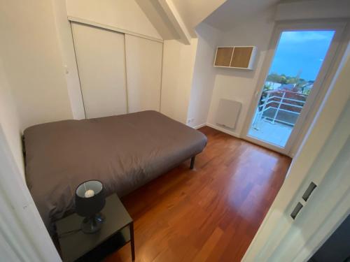 - une petite chambre avec un lit et une grande fenêtre dans l'établissement Superbe Appartement centre Sautron, à Sautron