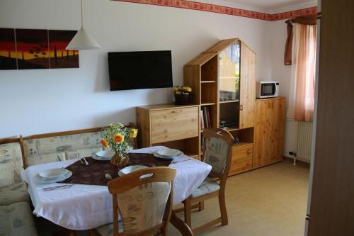 a dining room with a table and a television at Ferienwohnung Höbart in Dorfstetten