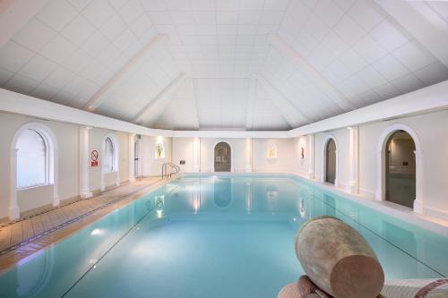 a large pool in a building with a ceiling at voco Oxford Thames by IHG in Oxford
