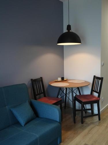a living room with a couch and a table at ADLER Room Suite in Łódź