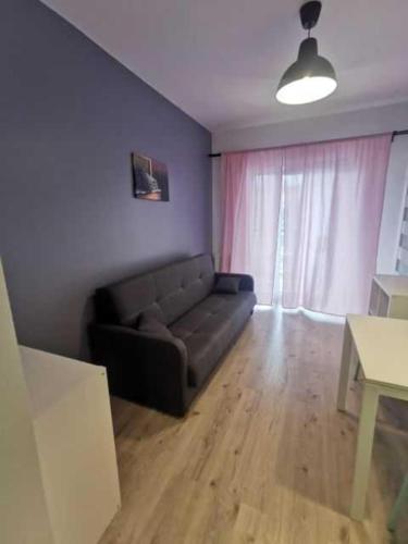 a living room with a couch and a table at ADLER Room Suite in Łódź