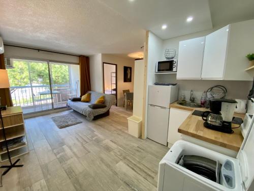 une cuisine et un salon avec un canapé et une table dans l'établissement La Citadelle du Soleil, au Grau-du-Roi