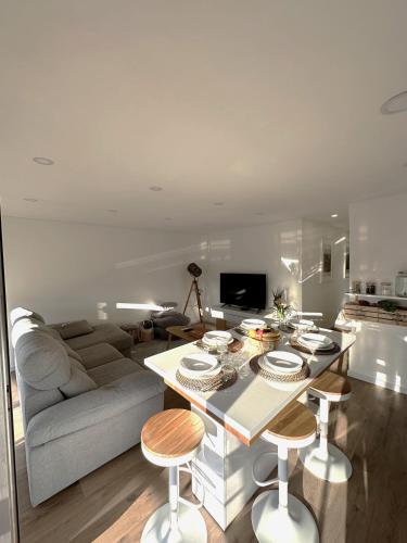 a living room with a couch and a table with stools at Fantástico T3 Porto - 6 Pessoas in Porto