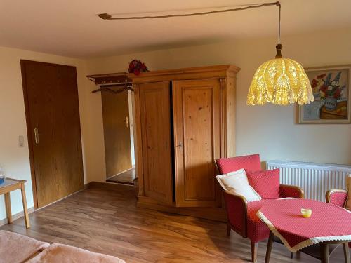 a living room with a table and chairs and a chandelier at Gästehaus Möschel in Weiler-Simmerberg