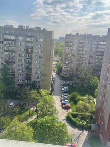 a city street with parked cars and tall buildings at apartament Prokocim in Krakow