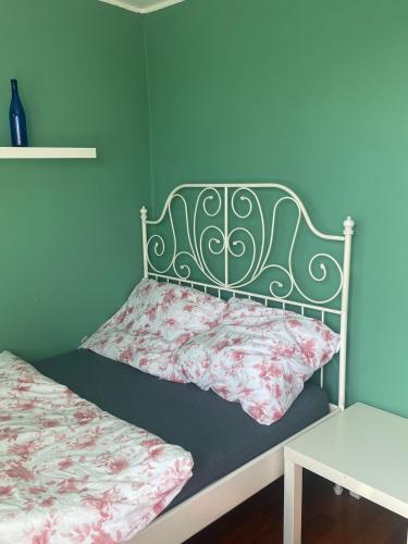 a bedroom with a bed with a green headboard at apartament Prokocim in Krakow