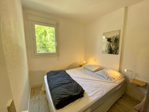 a bed in a room with a window at La Citadelle du Soleil in Le Grau-du-Roi