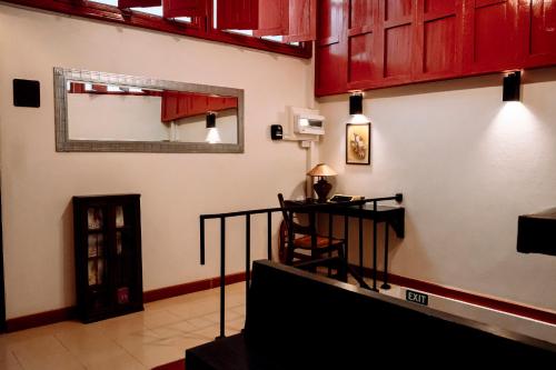 a living room with red cabinets and a mirror on the wall at Ubon Huan Kaew อุบลเฮือนแก้ว in Ban Na Khwai