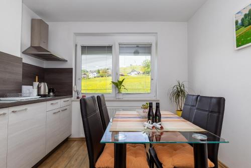 a kitchen and dining room with a table and chairs at Apartments & Wellness Dalija with Massages studio in Podčetrtek