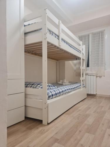 um quarto com 2 beliches num quarto branco em Trilocale nel centro di Sampierdarena em Gênova