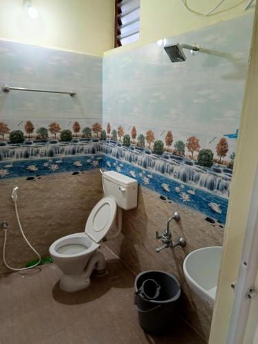 a bathroom with a toilet and a sink at Abaranji Guest House in Tiruvannāmalai