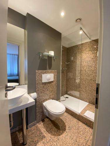 La salle de bains est pourvue de toilettes, d'un lavabo et d'une douche. dans l'établissement Paragon Apartments, à Francfort-sur-le-Main