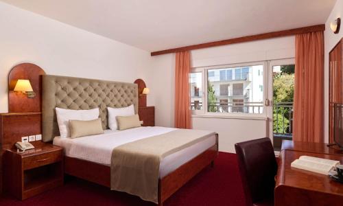 a hotel room with a bed and a window at Mediteran Maradiso Hotel by Aminess in Crikvenica