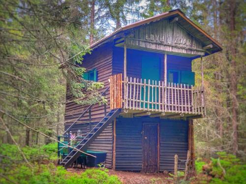 a blue cabin in the woods with a balcony at VLES chata uprostřed lesa in Prachatice