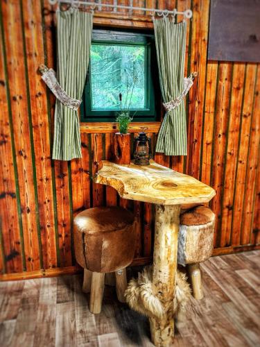 una mesa de madera y una ventana en una cabaña en VLES chata uprostřed lesa, en Prachatice
