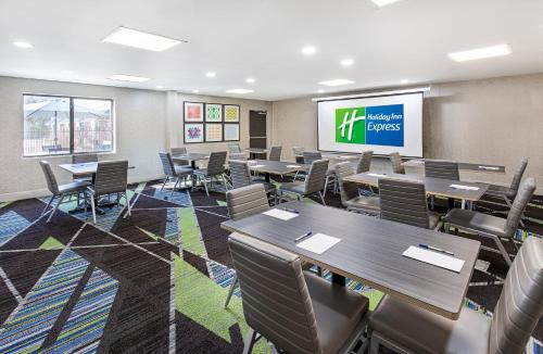 a conference room with tables and chairs and a screen at Holiday Inn Express Hotel & Suites Birmingham - Inverness 280 by IHG in Birmingham