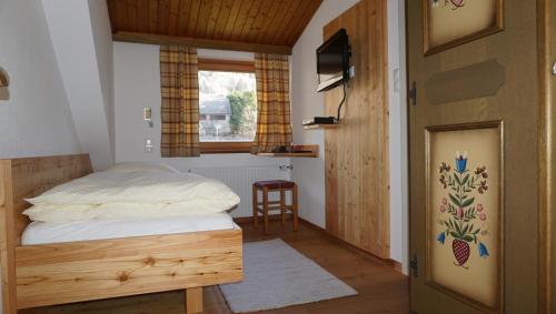 a bedroom with a bed and a table and a window at Gästehaus Hubertus in Malta
