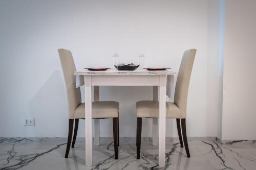 a table with two chairs and a white table with a plate at Hotel Cajeta in Buia