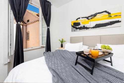 Un dormitorio con una cama y una mesa con fruta encima. en Rooms Eden Old Town 2, en Dubrovnik