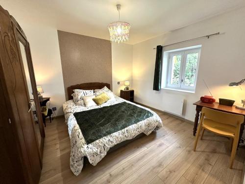 une chambre avec un lit, un bureau et une fenêtre dans l'établissement La massoune, à Rivière-Saas-et-Gourby