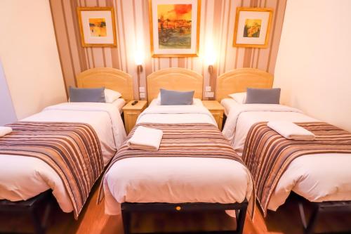 a group of four beds in a room at Fairway Hotel in London