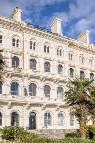 a large white building with a palm tree in front of it at FOX ON THE HOE in Plymouth