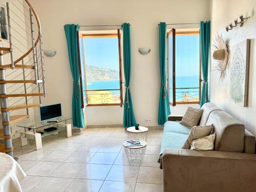 a living room with a couch and two large windows at Le St Julien Terrasse vue mer exceptionnelle in Menton