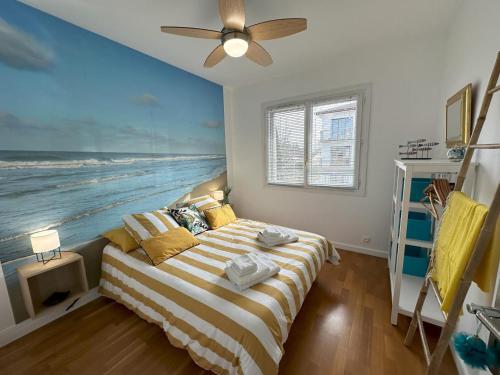 een slaapkamer met een bed en een schilderij van de oceaan bij Jules in Dax